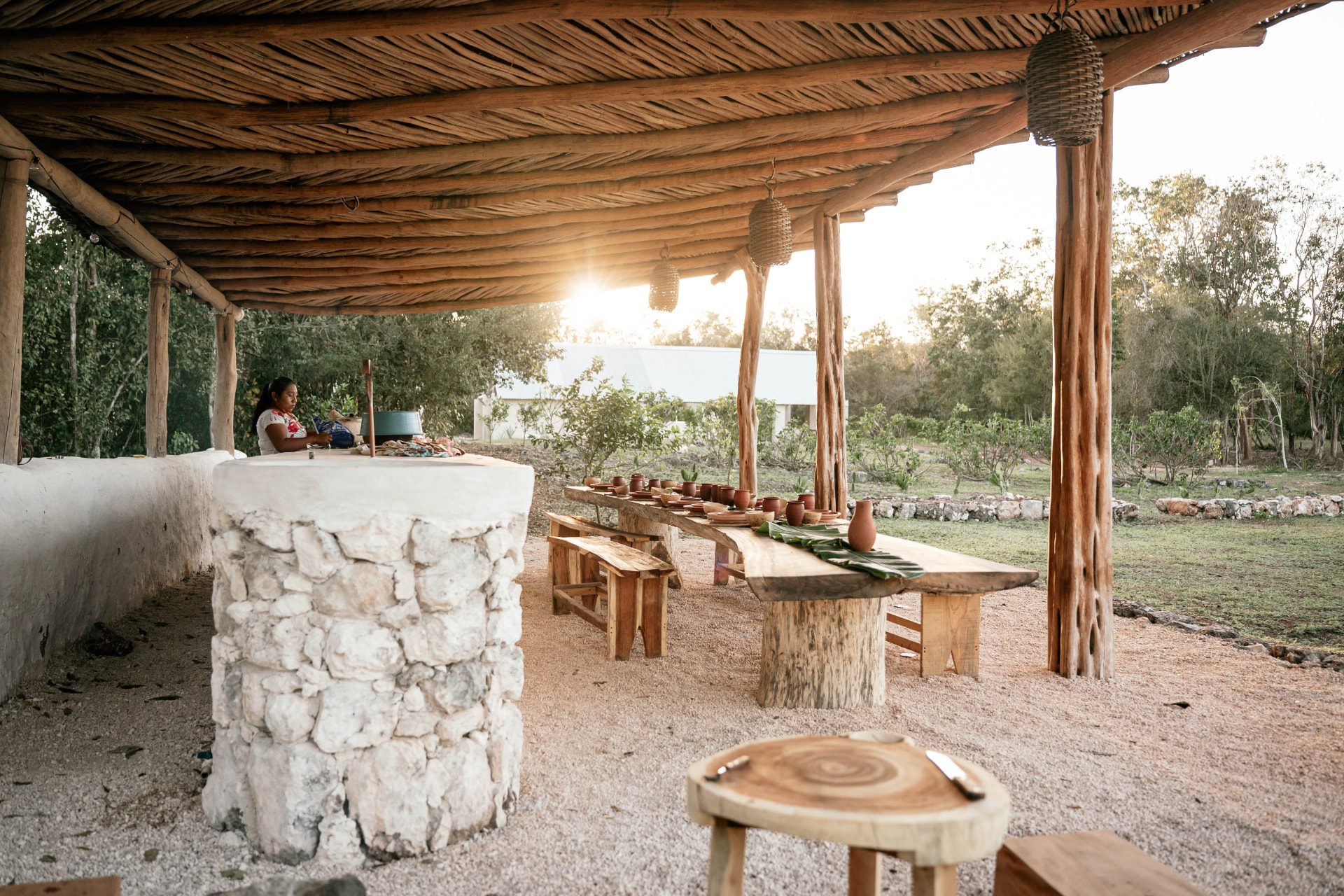 Mesa larga servida bajo la palapa de La Chan Cocinita al atardecer