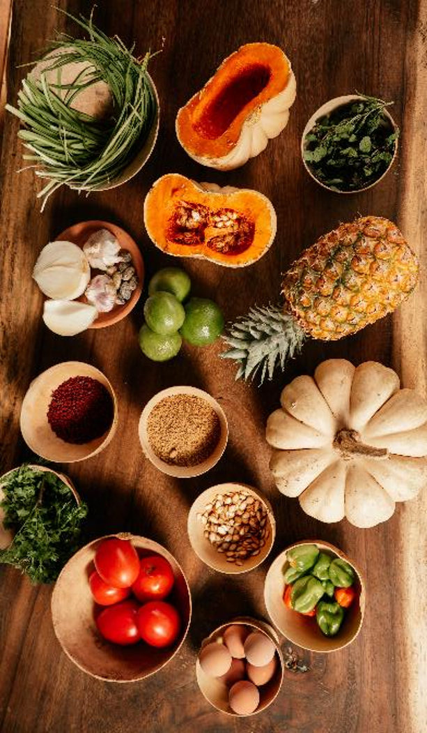 Ingredientes de temporada dispuestos en jícaras sobre una mesa de madera