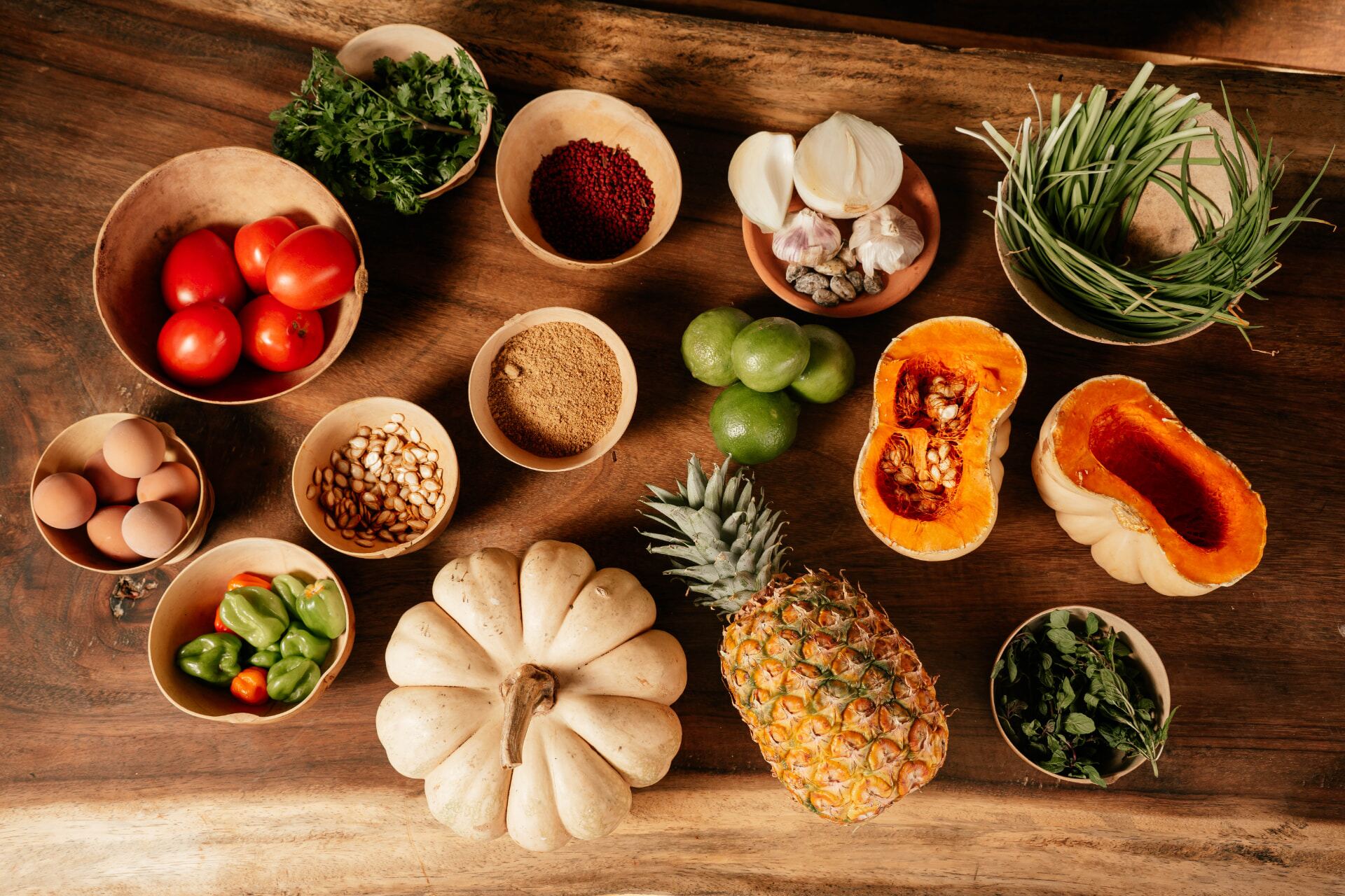 Ingredientes del día dispuestos en jícaras sobre una mesa de madera